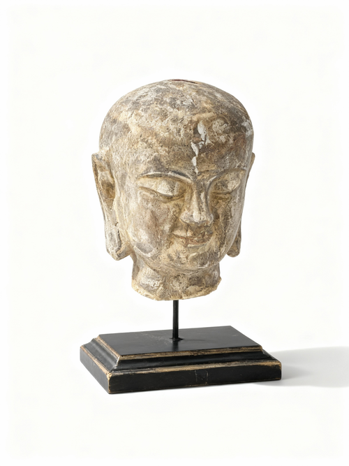 Asian statue head on a pedestal with soft lines and meditative expression