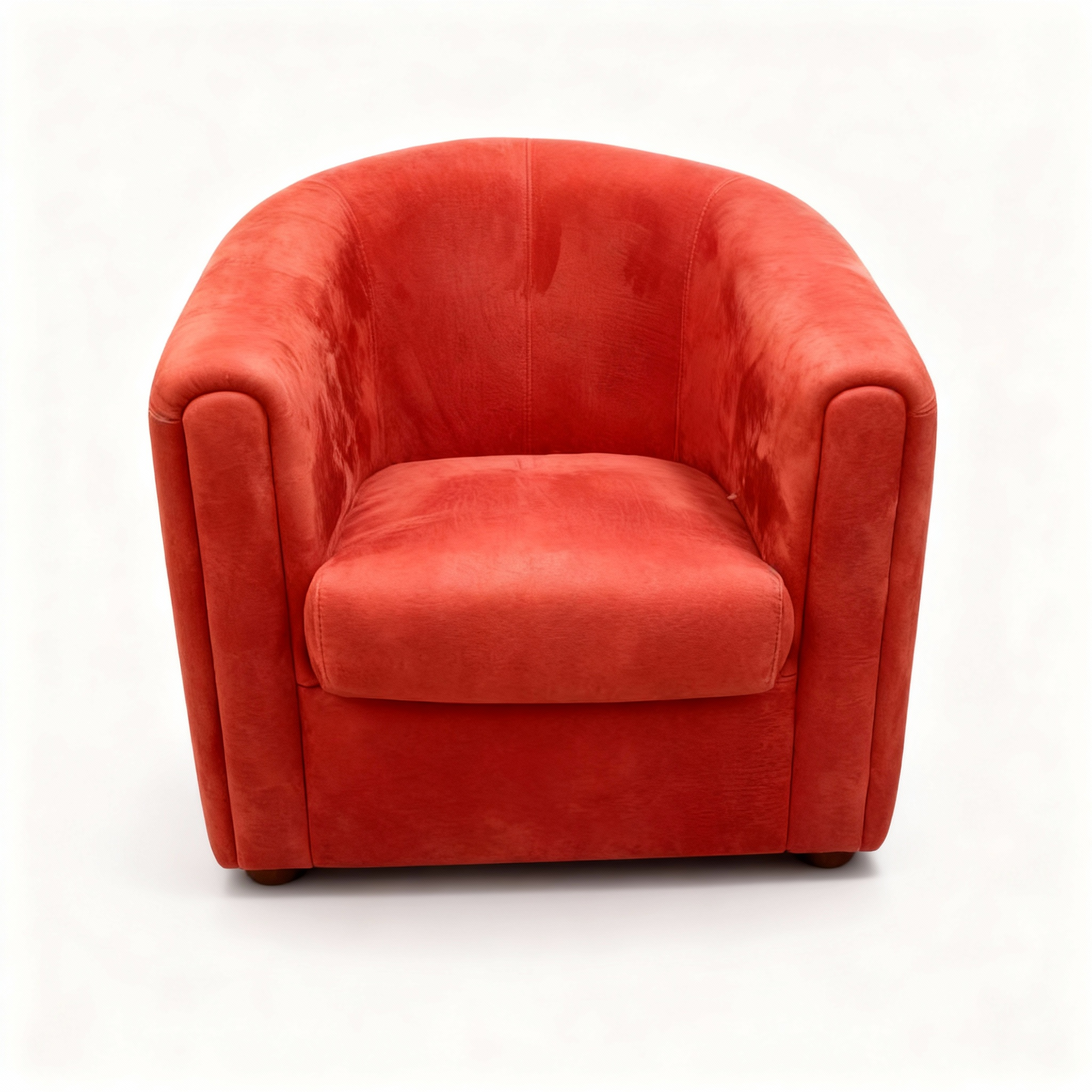 Modern club armchair with a rounded, cocooning shape, upholstered in vibrant coral-red nubuck leather, designed for deep seating comfort.