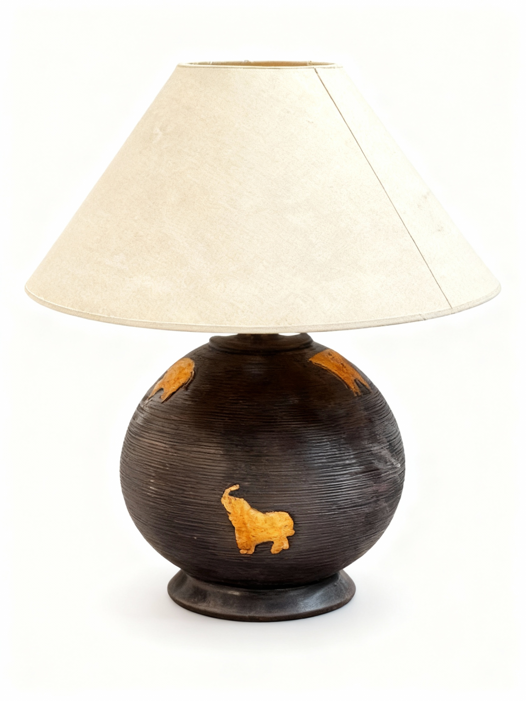 Table lamp with a round, dark textured ceramic/terracotta base featuring a gold elephant motif and a light beige conical fabric lampshade
