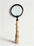 L'Explorateur decorative magnifying glass with dark frame and hand-carved ornamental handle