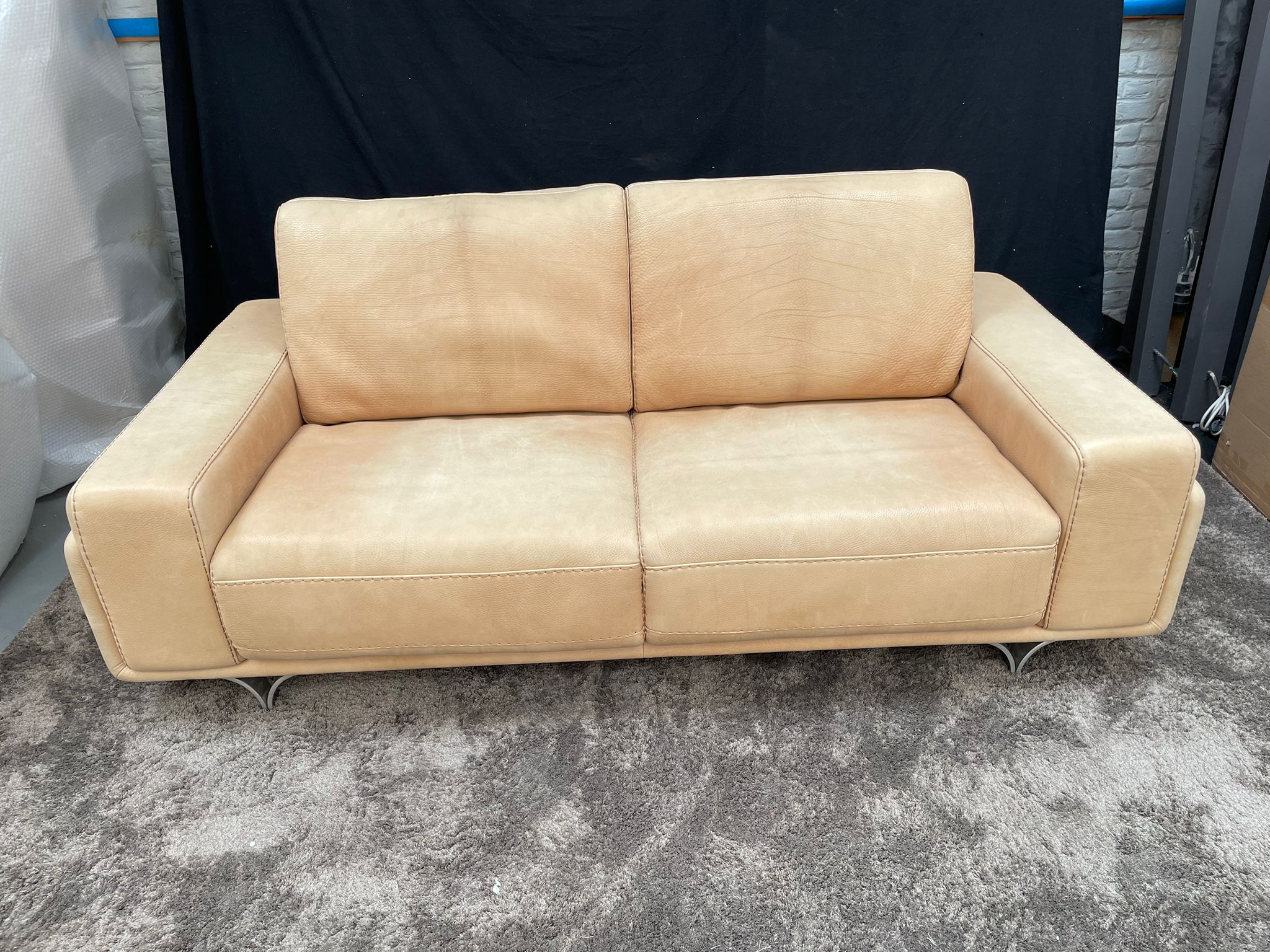 Contemporary "Metropolitan" sofa upholstered in sand-tone full-grain leather, featuring a sleek, low-profile design and signature polished chrome floating legs.