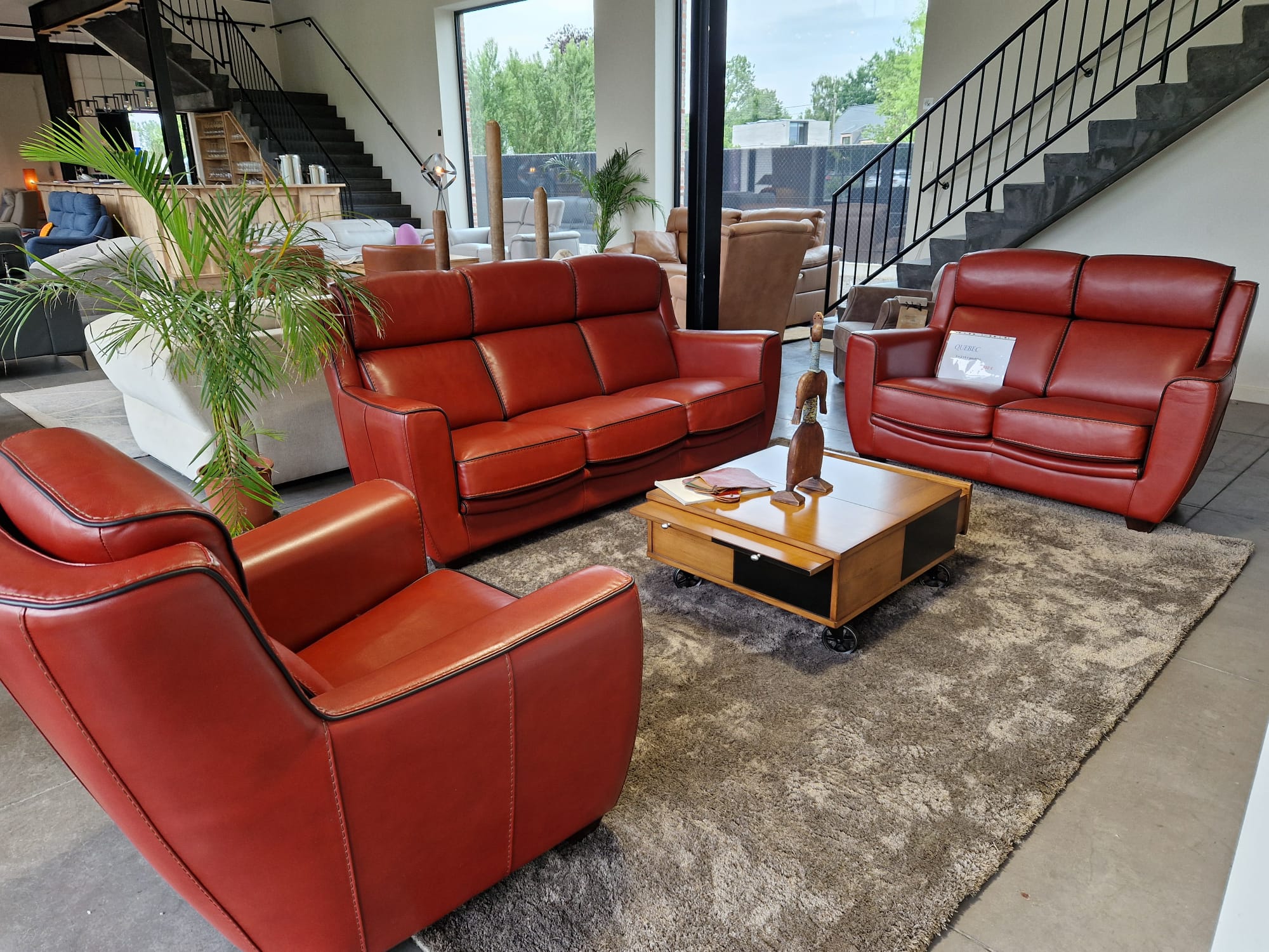 Complete "Québec" living room set featuring a 3-seater sofa, 2-seater sofa, and matching armchair, all upholstered in deep cognac full-grain leather with black piping.