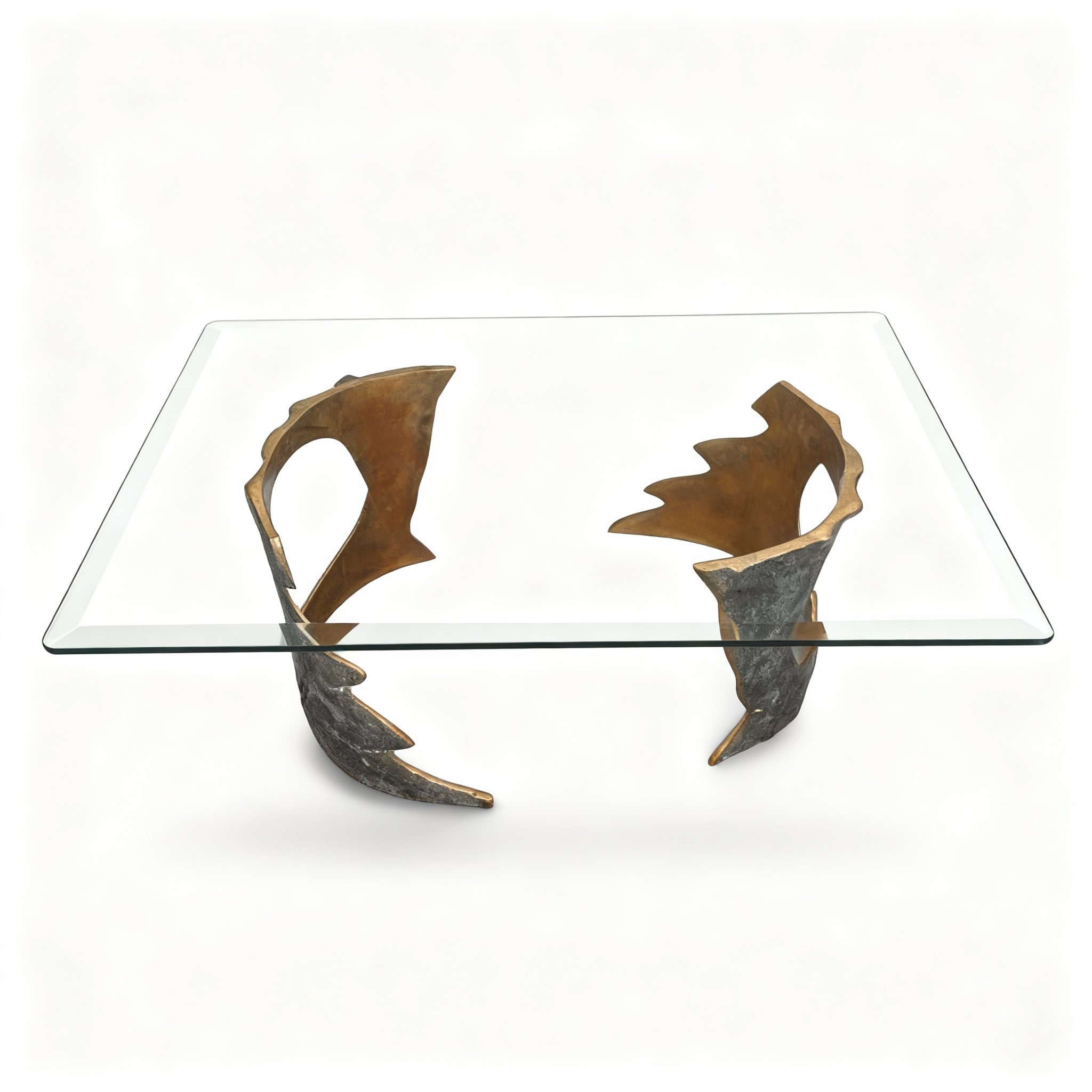 Rectangular coffee table (130x80x38.5cm) with a tempered glass top resting on two unique, hand-shaped metal bases finished in contrasting bronze and gold tones
