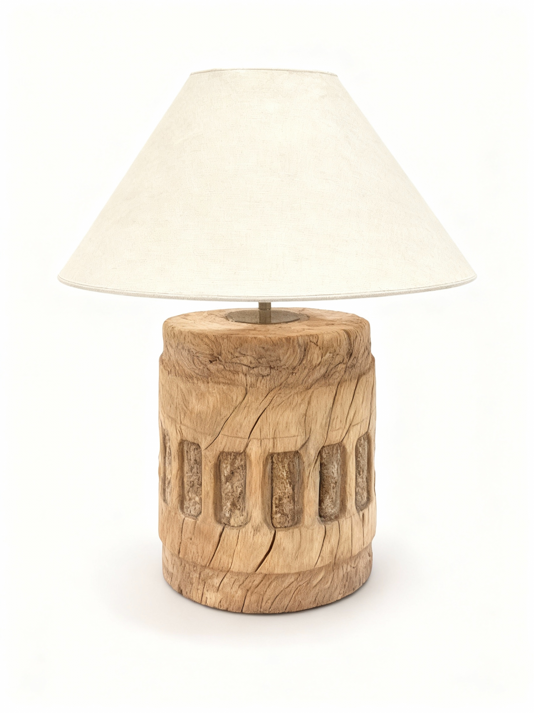 Table lamp with a raw, cylindrical solid wood base featuring carved patterns, natural cracks, and topped with an ecru conical fabric lampshade