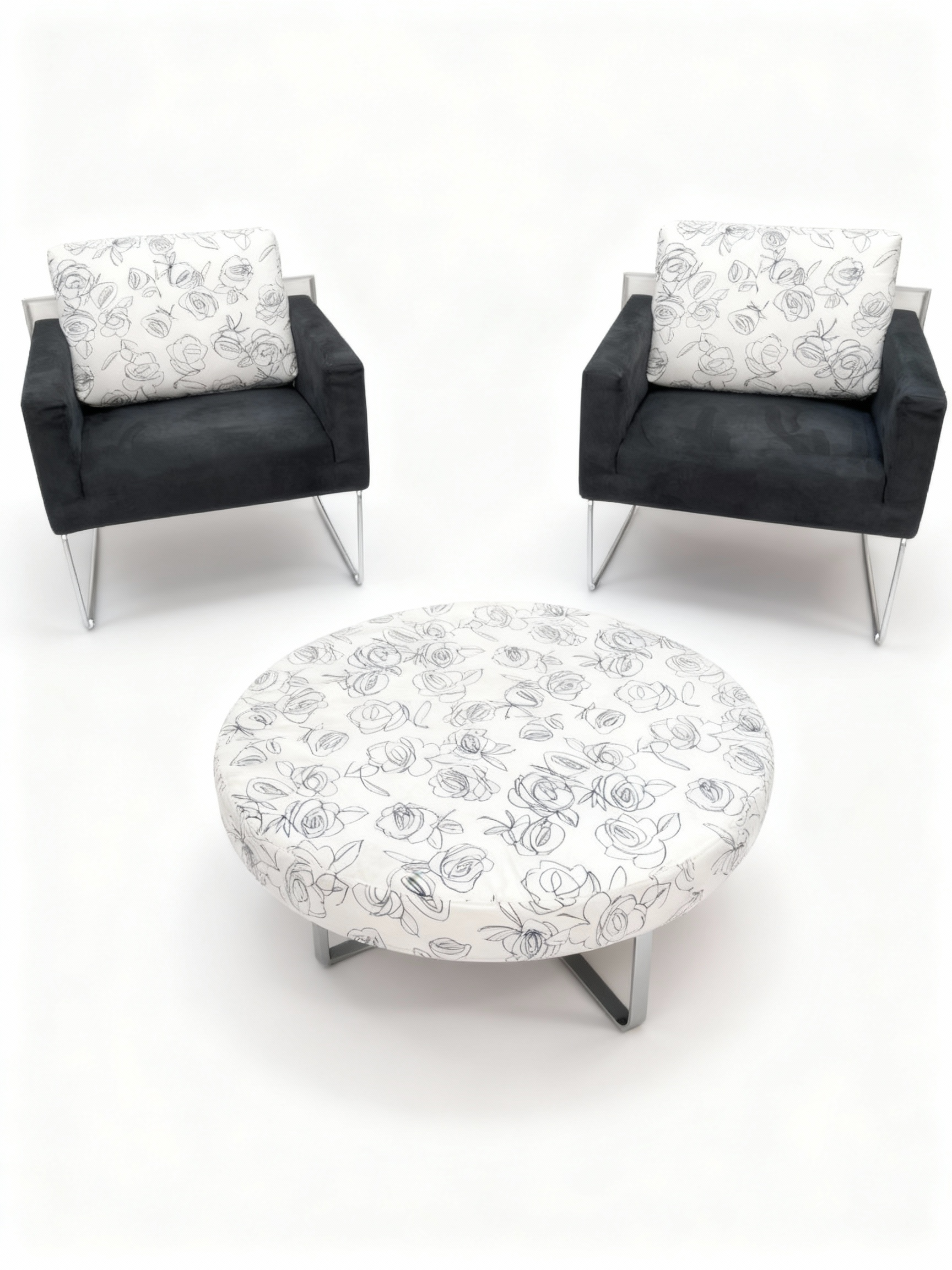 "VIRGOLA" 3-piece set including two low armchairs in deep black fabric and a round coffee table/ottoman with off-white and black floral graphic print, all on chrome legs