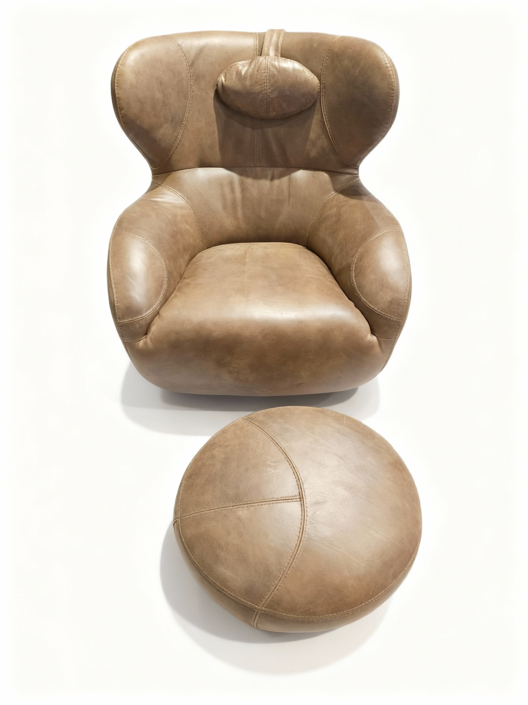 Enveloping armchair and matching ottoman set in vintage brown full-grain cowhide leather, featuring integrated lumbar support and a removable neck cushion