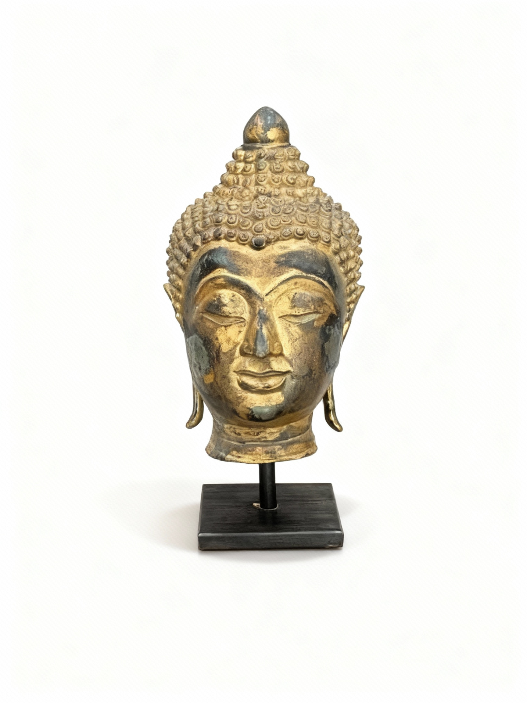 Vintage Buddha Head sculpture in richly patinated and gilded brass, mounted on a minimalist black pedestal, embodying serenity and exotic elegance